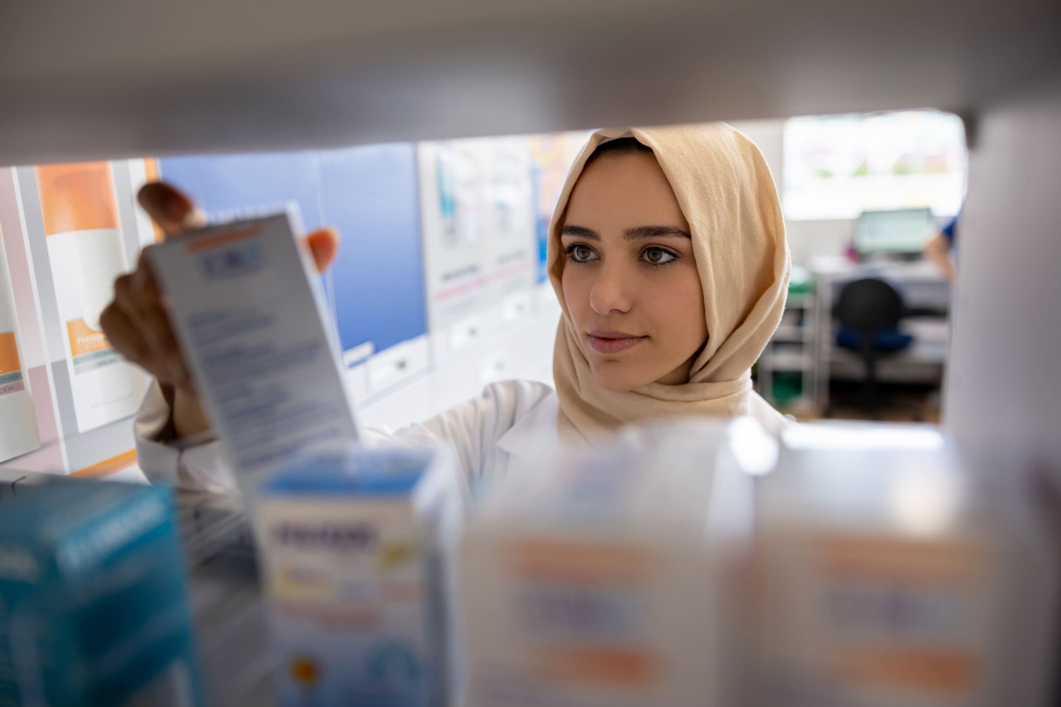 Muslim pharmacist working at a drugstore and searching for some medicines