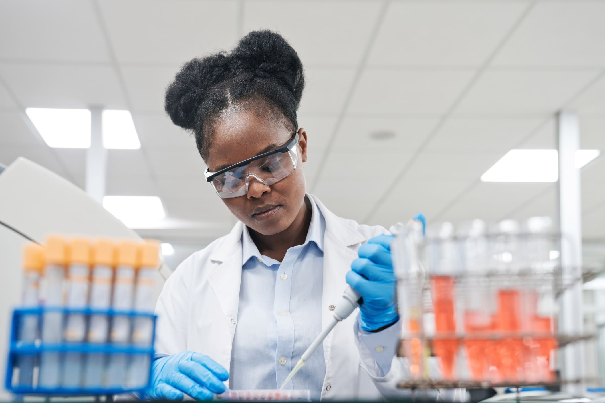 Young female scientist filling chemical through pipette while working in laboratory Clinical Trials