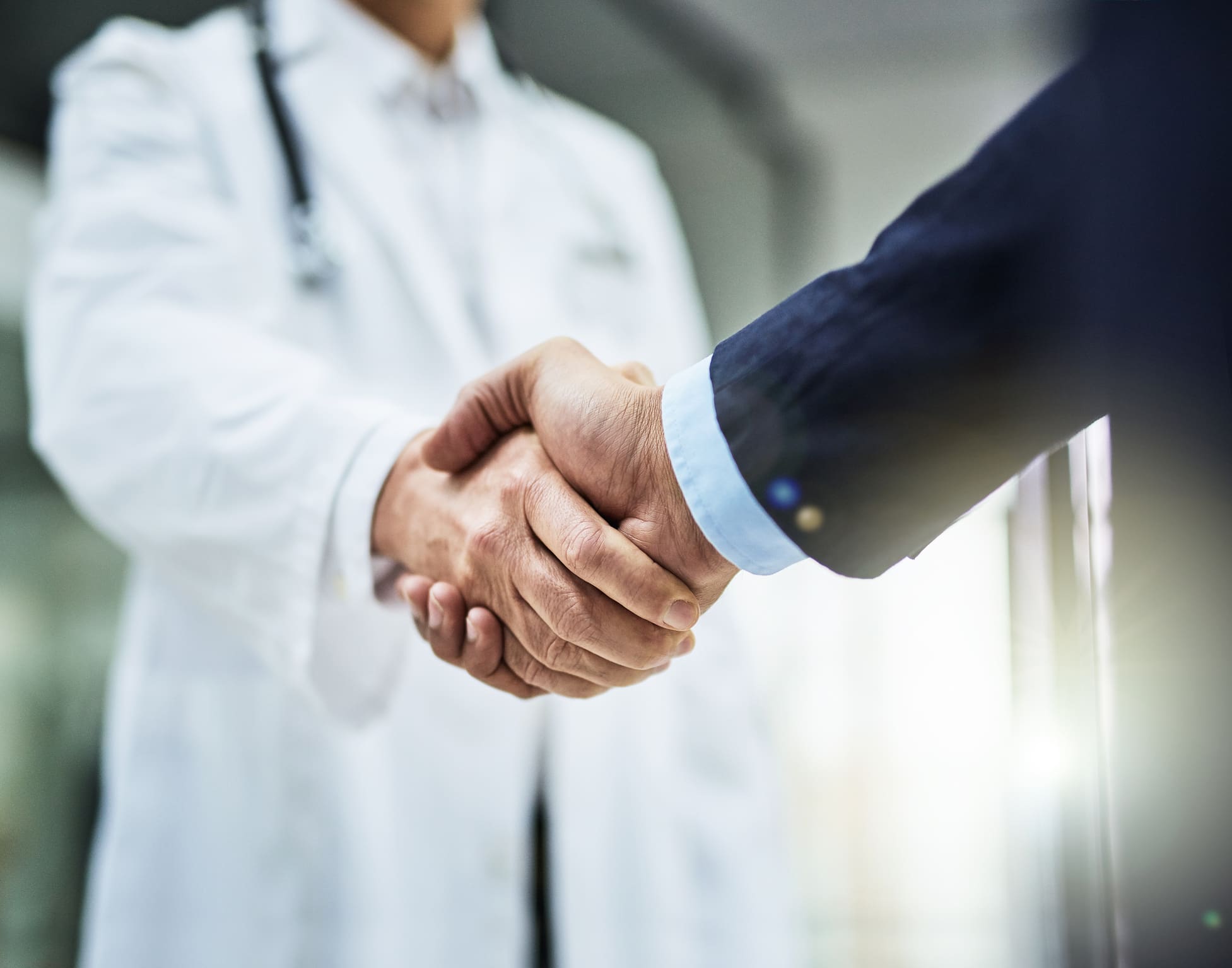 Health is wealth Doctor and business representative shaking hands after completing a business deal.